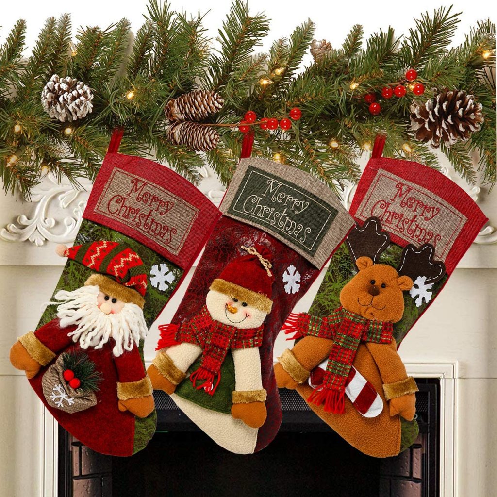 3 needlepoint Christmas stockings on display on a fireplace mantle